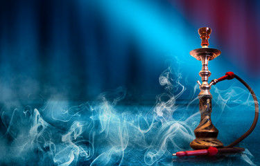 Hookah with smoke on the background of an empty scene, wet asphalt and colored neon light.