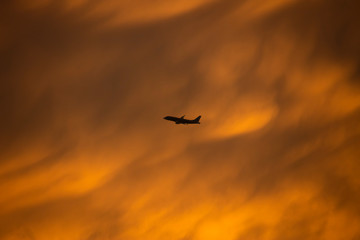 A yellow turbulence cloud with silhouette airplane flying through