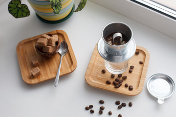 Alternative coffee brewing method set. Stylish accessories and items for alternative coffee on windowsill. Espresso in glass, coffee beans, filters
