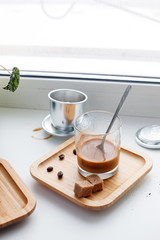 Alternating filter manual brewing of coffee close up. Devices for coffee in the background, coffee with sweetened condensed milk in glass, hipster morning routine concept