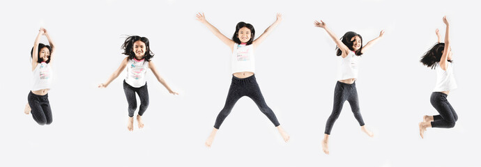 Asian funny child girl jumping on gray background.