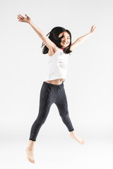 Asian funny child girl jumping on gray background.