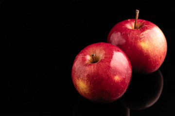 two red apples on a black background