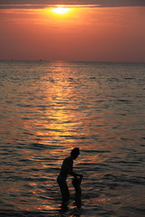 Silhouette of adorable little girl on a beach at sunset