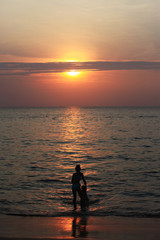 Fototapeta premium Silhouette of adorable little girl on a beach at sunset