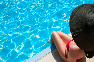 Woman in red bikini relaxing in swimming pool.