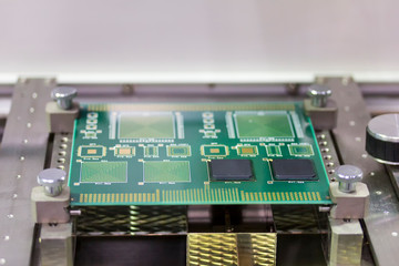 close up green electronic printed circuit board (pcb) for computer or equipment setup on jig at...