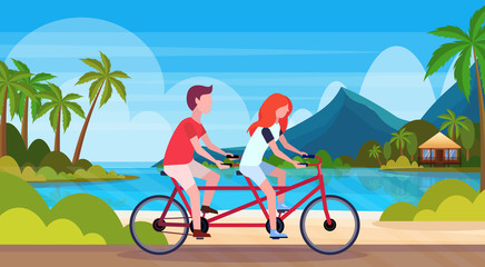 Fototapeta premium couple in love riding tandem bicycle summer vacation sea beach landscape beautiful seaside man woman lovers cycling twin bike horizontal flat