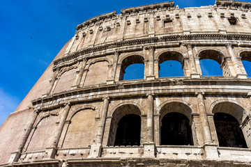 Naklejka premium Facade of the Great Roman Colosseum (Coliseum, Colosseo), also known as the Flavian Amphitheatre. Famous world landmark