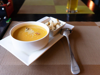 Soup puree sprinkled with sesame seeds, croutons of white bread.