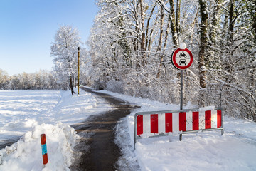 Weg f&uuml;hrt an roten Verkehrsschildern vorbei durch den Schnee in der Sonne, M&uuml;nchen
