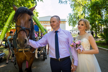 Russian bride and groom together in green city park