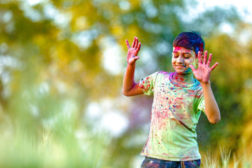 Indian child playing with the color in holi festival