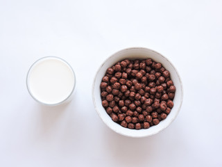 Pouring milk in the glass on blue background. Fresh milk pouring making a crown splash. Front view. Milk glass top view. Natural ingredients concept. Tasty healthy products on a table,selective focus.