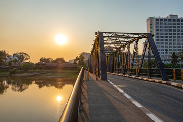 Iron bridge in Chiangmai during sunset time with sun reflection