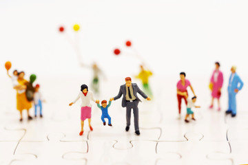Miniature people: family and children enjoy with colorful balloons, happy family day concept.