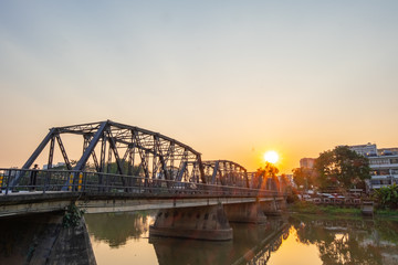 Iron bridge in Chiangmai during sunset time with beautiful lens flare.