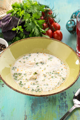 plate of white fish soup on blue wooden table