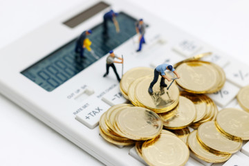 Miniature people: Workers working on golden coins with calculator. Finance, investment and growth in business concept.