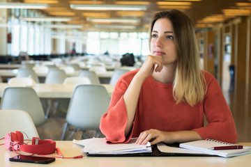 Young female student studying in the library.