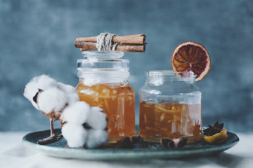 Homemade orange jam in glass jar on blue or grey background