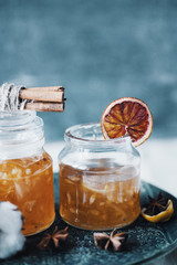 Homemade orange jam in glass jar on blue or grey background
