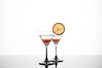 martini glass on a white background with an orange slice.
