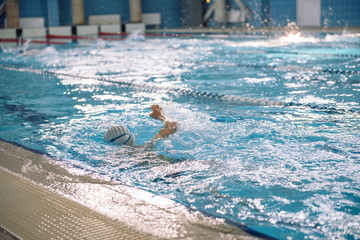 Competitions in the pool. Children in the pool without a face. Spray in the pool. Swim for speed.
