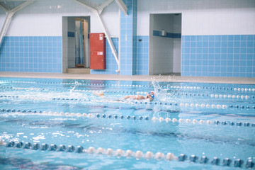 Competitions in the pool. Children in the pool without a face. Spray in the pool. Swim for speed.