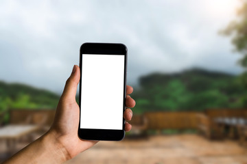 2. Hand that are holding a black phone with a blank white screen in the morning light of an air residence.