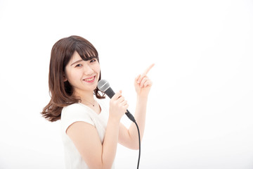 マイクを持って笑顔でジェスチャーする女性