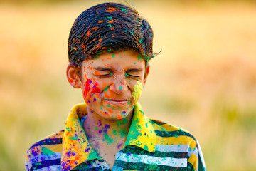 Indian child playing with the color in holi festival