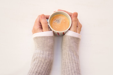 Las manos de una mujer sujetando una taza de cafe