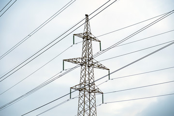 Power lines with many wires and metal supports on the open water against the sky