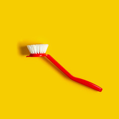 Bright red brush lies on a bright yellow background. In the style of pop art. Top view. Copy space.
