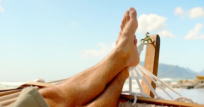 Close up of man foot rested on a hammock at beach 4k