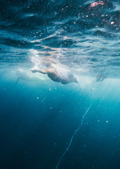 Swimming passing a submerged bouy duing a race off the coast of Hilo Hawaii.