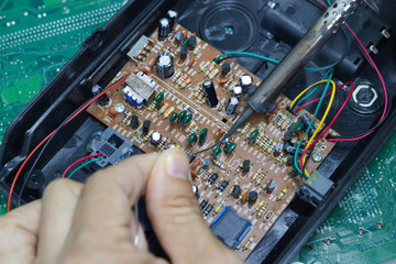 Technician repairing electronic of the computer's circuit board by soldering Irons, concept ...