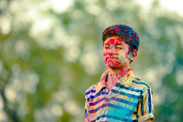 Indian child playing with the color in holi festival