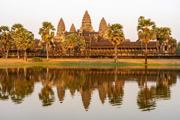 Angkor Wat temple with reflections in moat in golden sunset light