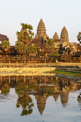 Fototapeta premium View of Angkor Wat temple on sunset in golden light with reflection in the pond