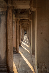 Covered gallery with striped shadows of columns in Angkor Wat temple
