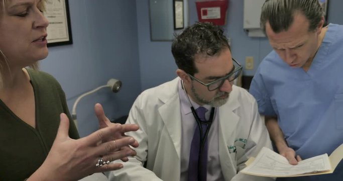 Nurse or surgeon interrupting a female patient talking to her male doctor