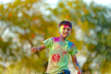 Indian child playing with the color in holi festival