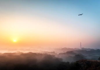 An early morning winter sunrise with fine layer of mist at the most iconic Qutub Minar in the capital city of New Delhi.