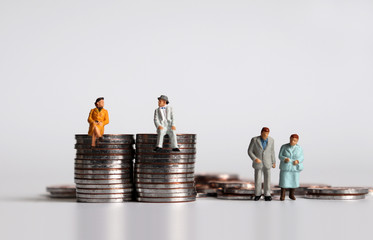Coins with miniature people. Concepts of old age and the gap between rich and poor.