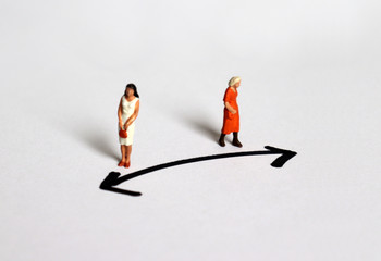 Two miniature women who stand in a different direction.