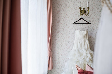 Bride dress on a hanger in the elegant interior of the hotel