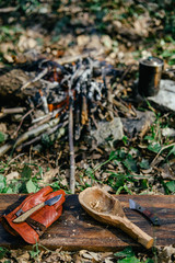 Man carving grilled rabbit meat in forest camp. Top view. Bushcraft concept 