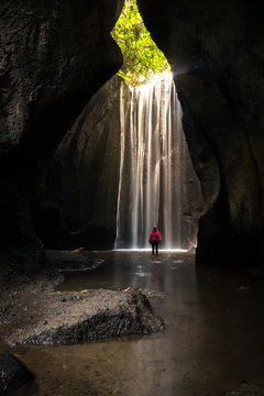 Sunbeam coming from the top of a huge waterfall inside a cave in Bali